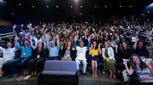 Foto do evento com o Professor Yunus. É um auditório, com várias pessoas sentadas, sendo que o professor Yunus está sentado na primeira fileira ao centro.